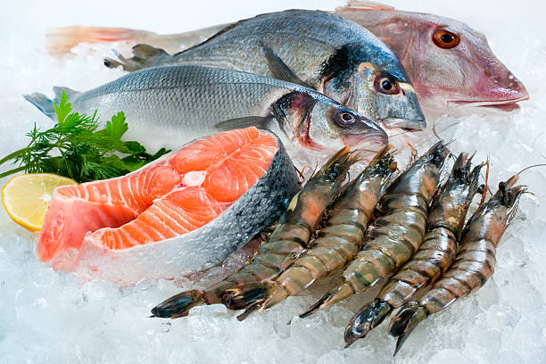 Whole fish, salmon steak and prawns on crushed ice